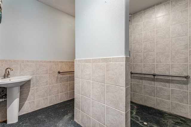 bathroom featuring tile walls and sink