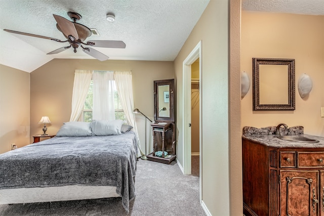 bedroom with sink, a textured ceiling, ceiling fan, and light colored carpet