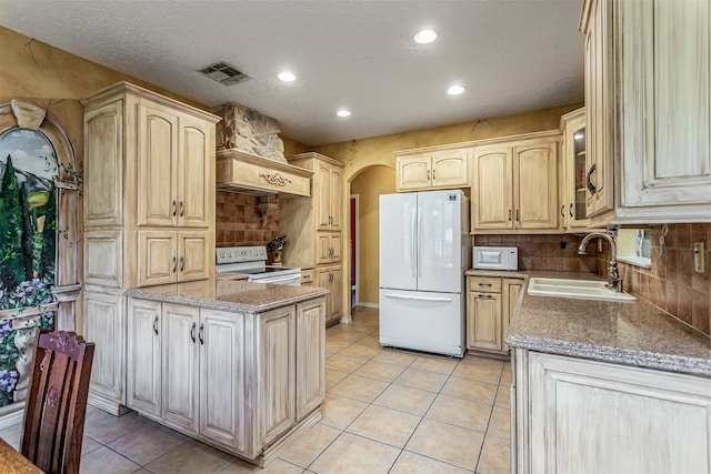 kitchen featuring sink, light tile patterned floors, tasteful backsplash, and white appliances