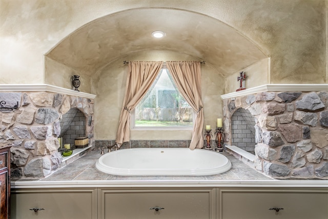 bathroom with a stone fireplace and a washtub