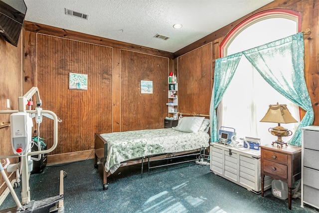 bedroom with wood walls and a textured ceiling