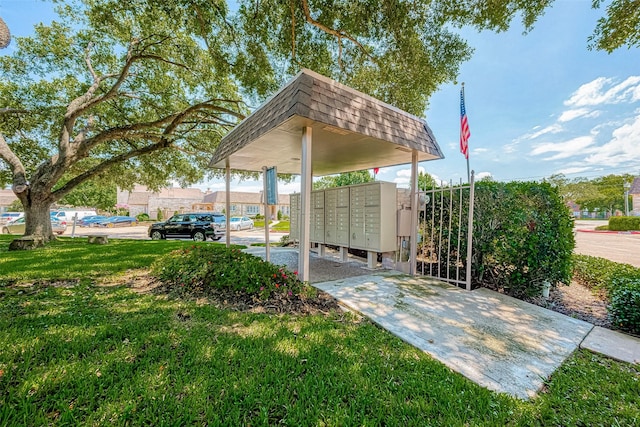 surrounding community featuring mail boxes and a yard