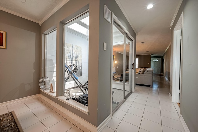 hallway with crown molding, light tile patterned flooring, and a textured ceiling