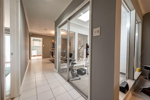 gym with crown molding and light tile patterned floors