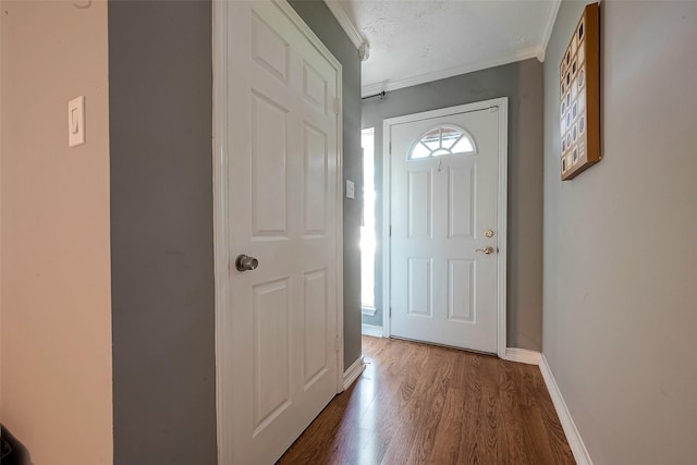 entryway with ornamental molding, dark hardwood / wood-style floors, and a textured ceiling