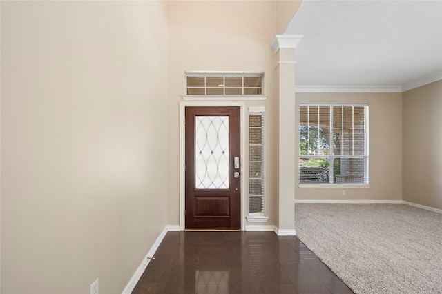 foyer with dark colored carpet and ornamental molding