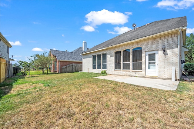 back of house with a yard and a patio area