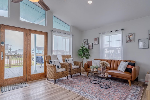 living room featuring light wood-type flooring, ceiling fan, a wealth of natural light, and lofted ceiling