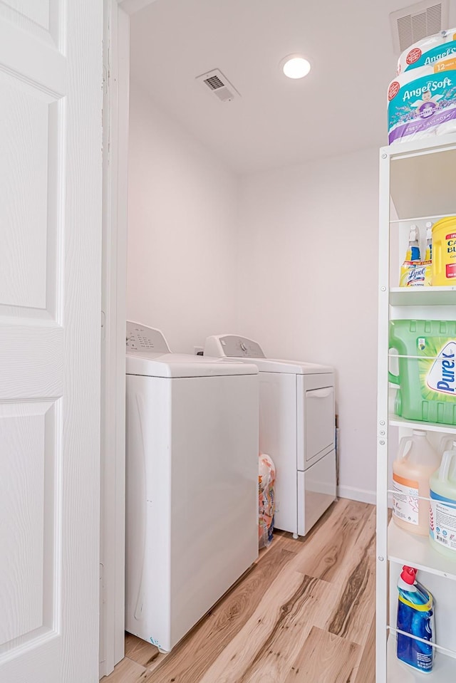 washroom with washer and dryer and light wood-type flooring