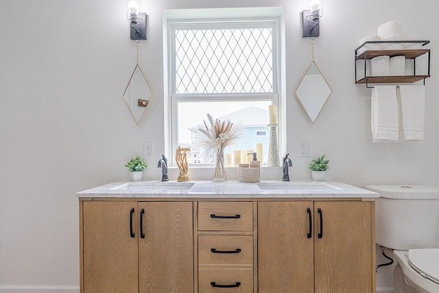 bathroom featuring toilet, vanity, and a wealth of natural light