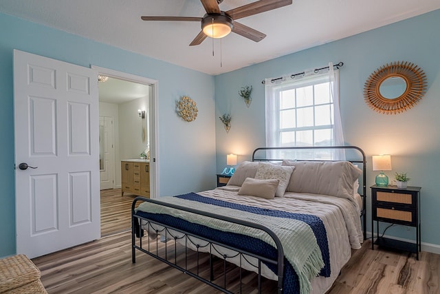 bedroom featuring ceiling fan, hardwood / wood-style floors, and connected bathroom