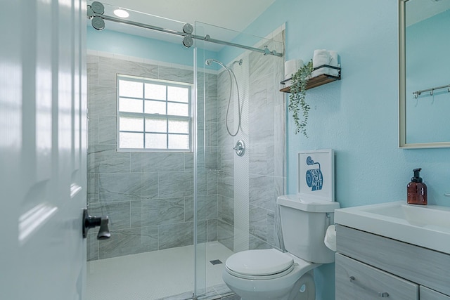 bathroom featuring toilet, vanity, and walk in shower