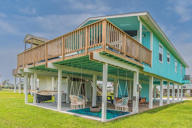 back of house with a patio area, a wooden deck, and a lawn