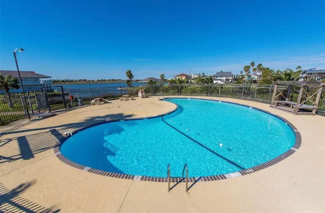 view of pool with a water view and a patio