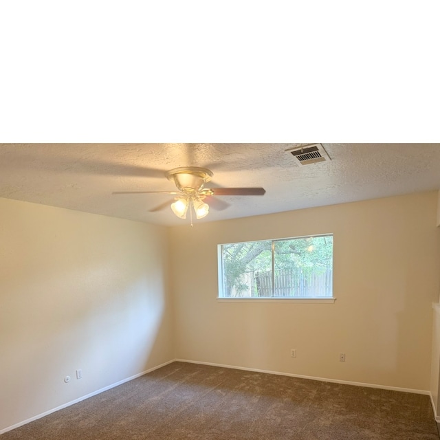 carpeted spare room featuring ceiling fan and a textured ceiling