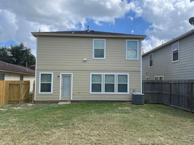 rear view of property with a lawn and cooling unit