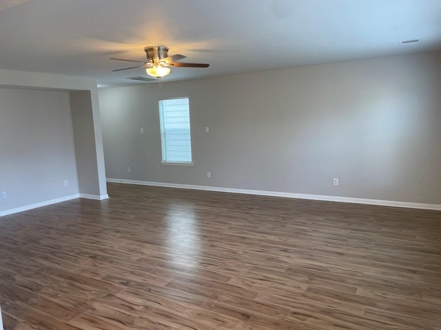 spare room featuring dark hardwood / wood-style flooring and ceiling fan