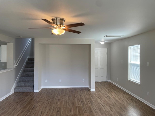 unfurnished living room with ceiling fan and dark wood-type flooring