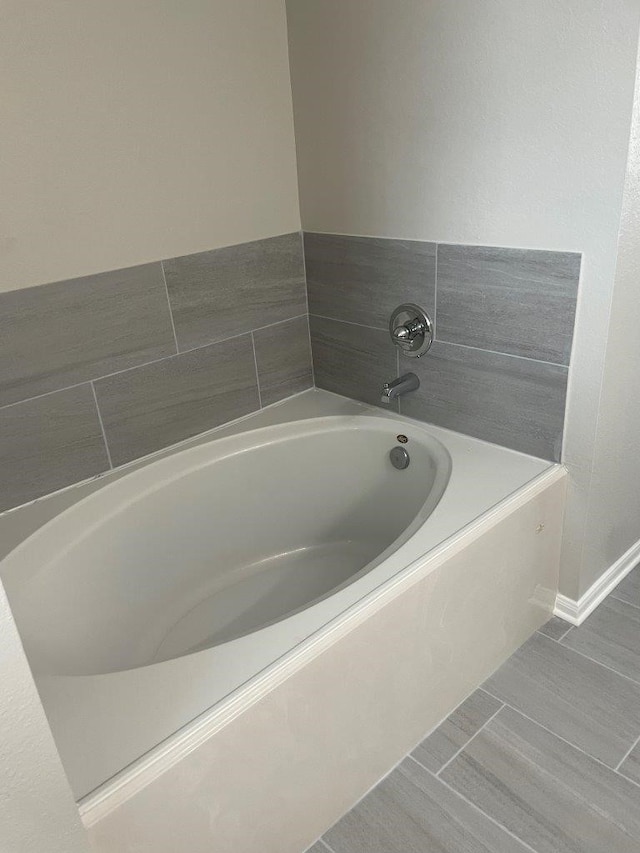 bathroom with a washtub and tile patterned flooring