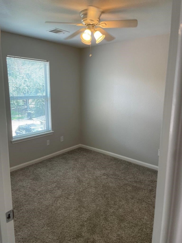 carpeted spare room featuring ceiling fan