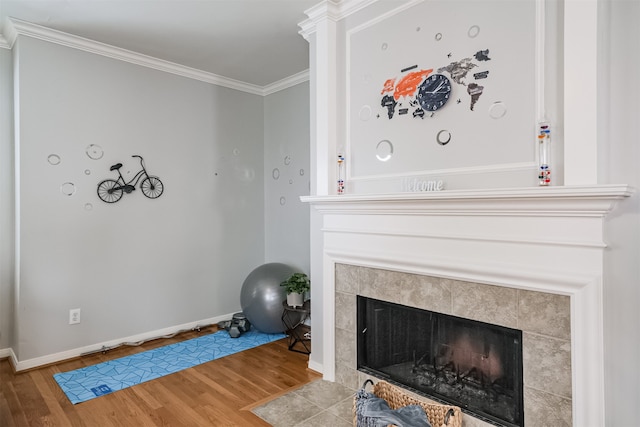 interior space featuring wood-type flooring, a tile fireplace, and ornamental molding