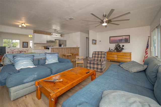 living room featuring ceiling fan and light hardwood / wood-style floors