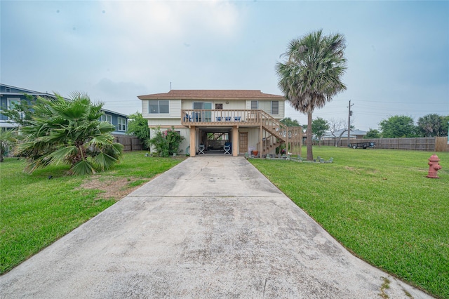 view of front facade with a deck and a front lawn