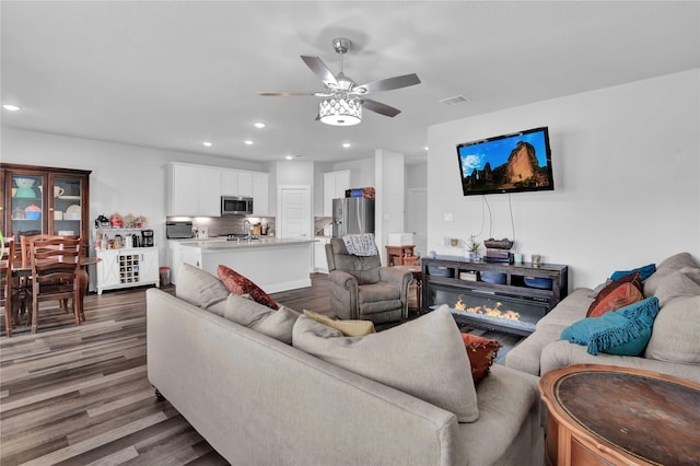 living room with ceiling fan, dark hardwood / wood-style flooring, and sink