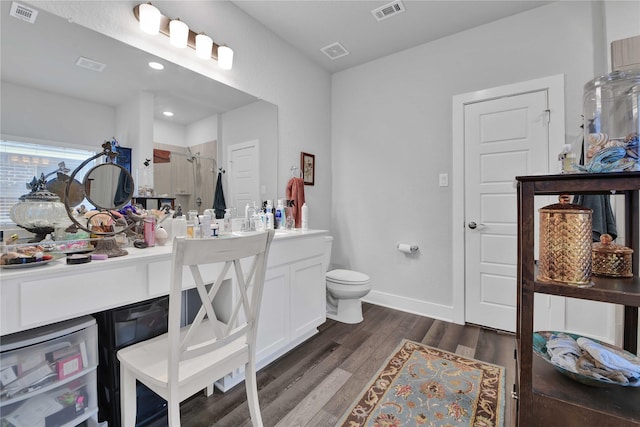 bathroom with vanity, hardwood / wood-style flooring, a shower with shower door, and toilet