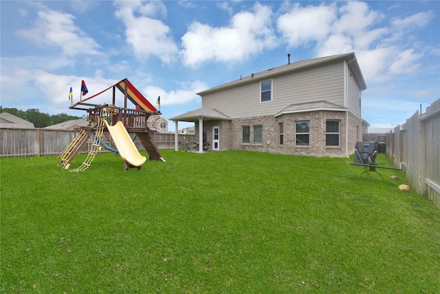 back of property featuring a playground and a yard