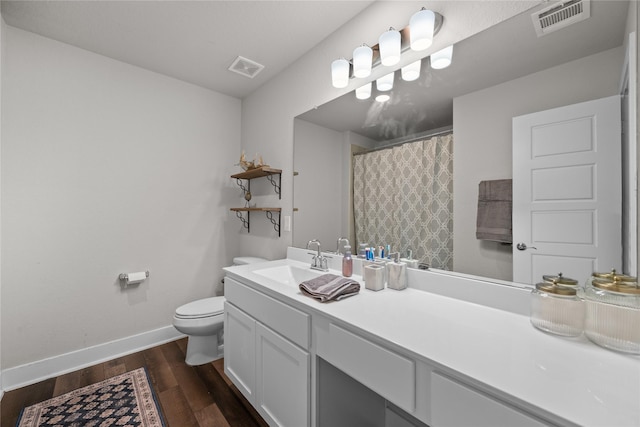 bathroom with vanity, wood-type flooring, and toilet