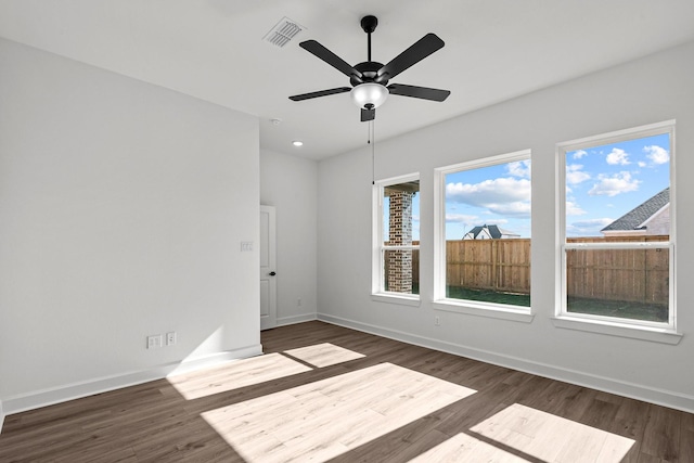 empty room with dark hardwood / wood-style floors and ceiling fan