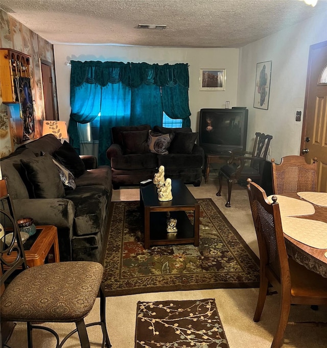 carpeted living room featuring a textured ceiling