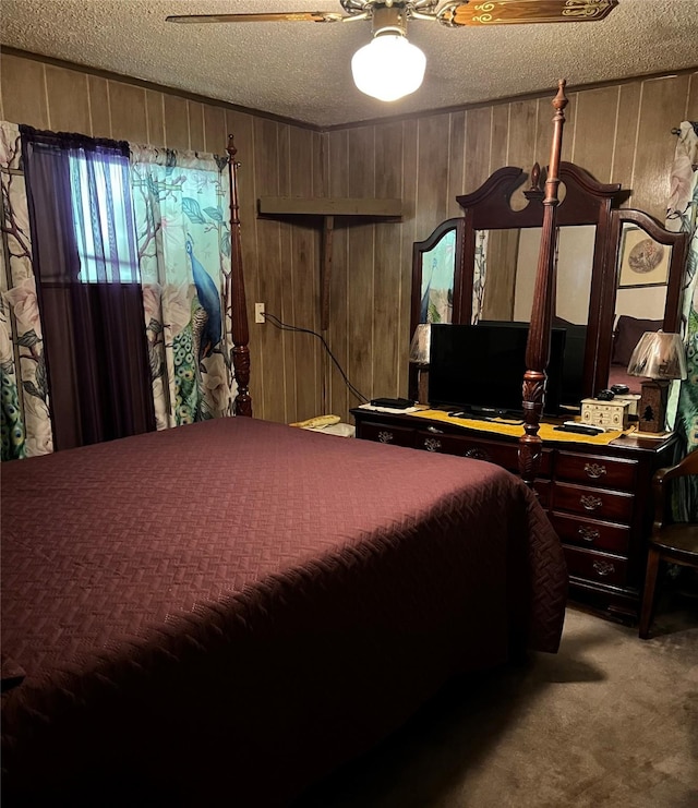 carpeted bedroom featuring ceiling fan, wooden walls, and a textured ceiling