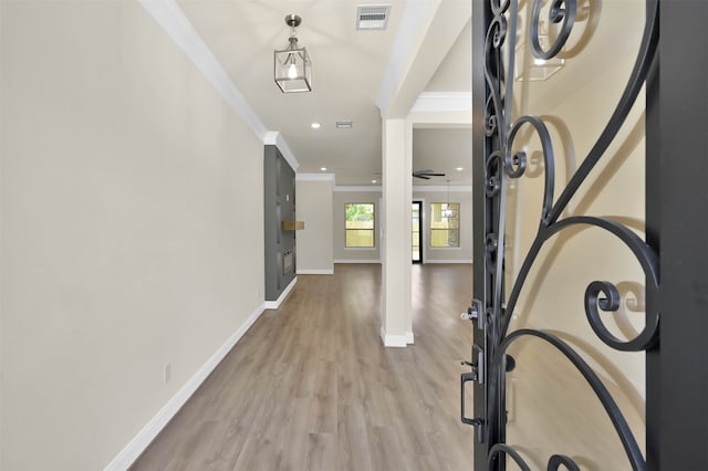 foyer with crown molding and light hardwood / wood-style flooring