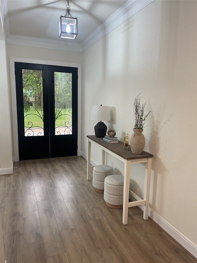 entryway with crown molding, dark wood-type flooring, and french doors