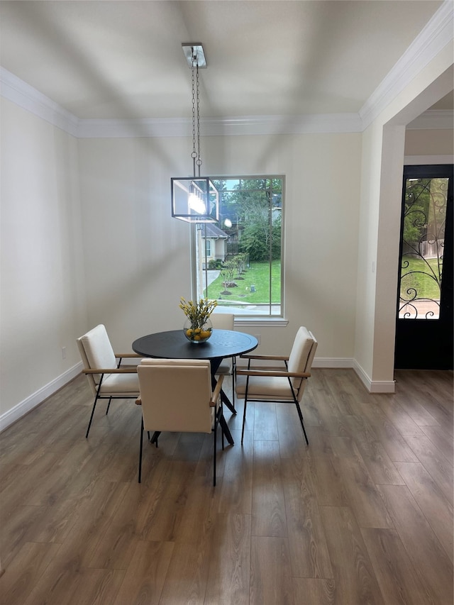 dining area featuring a chandelier, ornamental molding, hardwood / wood-style flooring, and a wealth of natural light