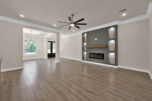 unfurnished living room featuring dark wood-type flooring, ornamental molding, and ceiling fan