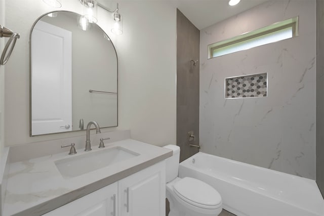 full bathroom with vanity, tiled shower / bath combo, and toilet