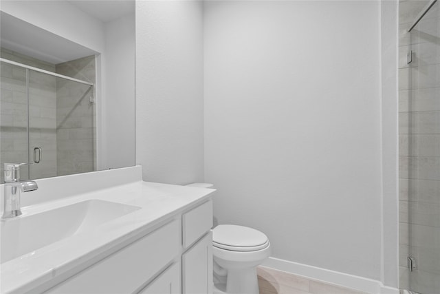 bathroom with tile patterned flooring, vanity, a shower with shower door, and toilet