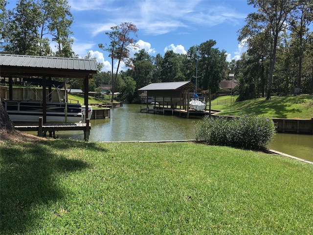 view of dock with a lawn, a water view, and boat lift