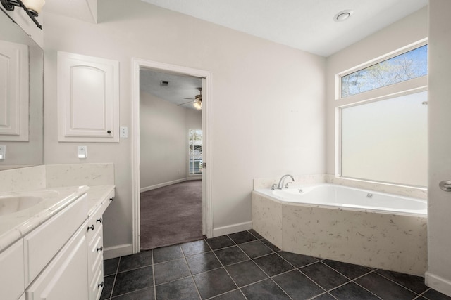 full bath featuring vanity, a garden tub, tile patterned flooring, baseboards, and ceiling fan