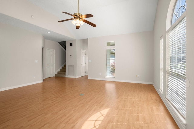 unfurnished living room with light wood-style flooring, baseboards, stairs, and ceiling fan
