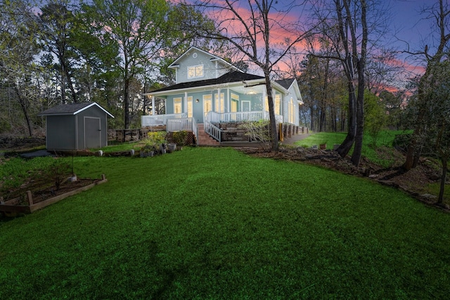 view of front of property featuring an outbuilding, a storage unit, a garden, a porch, and a yard