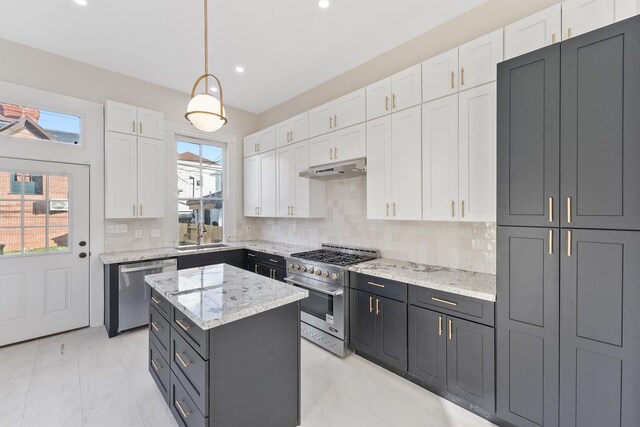 kitchen featuring white cabinets, decorative backsplash, decorative light fixtures, a kitchen island, and stainless steel appliances