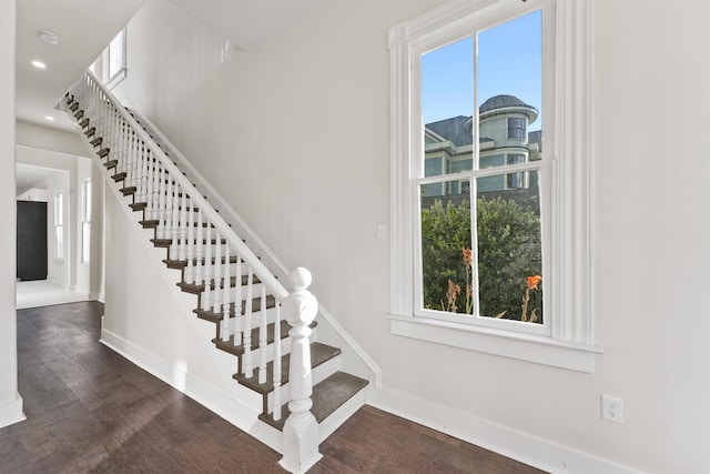 stairs featuring plenty of natural light, baseboards, and wood finished floors