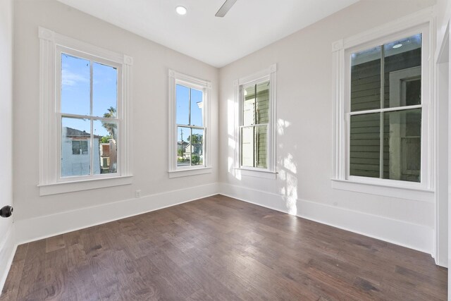 unfurnished room with plenty of natural light, dark wood-type flooring, and ceiling fan