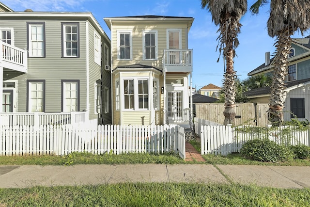 view of front of home with a fenced front yard and a balcony