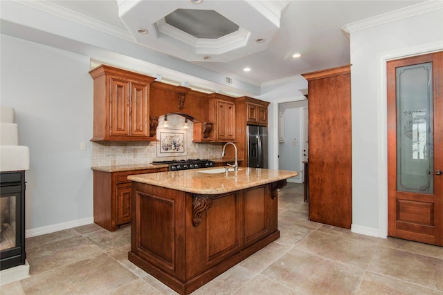 kitchen featuring an island with sink, sink, stainless steel fridge, a kitchen breakfast bar, and light stone counters