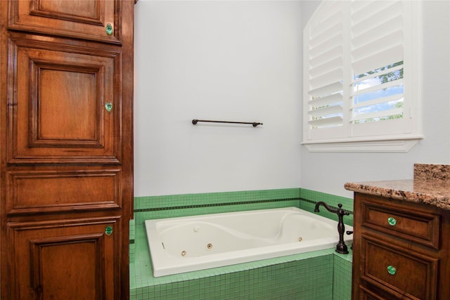 bathroom with tiled tub and vanity